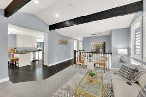 Living room with dark carpet, dark wood-type flooring, and recessed lighting