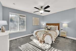 Carpeted bedroom with baseboards and ceiling fan