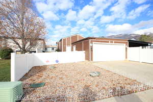View of property exterior with concrete driveway, an attached garage, and a mountain view