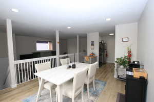 Dining room with light wood finished floors and recessed lighting