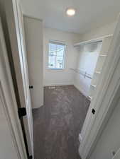 Walk in closet featuring dark colored carpet