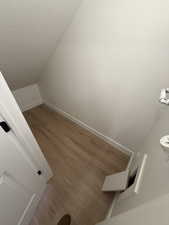Stairs featuring a textured ceiling and wood finished floors