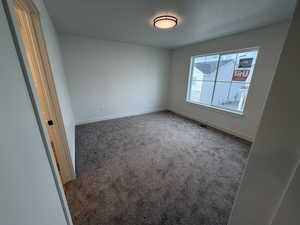 Carpeted empty room featuring baseboards