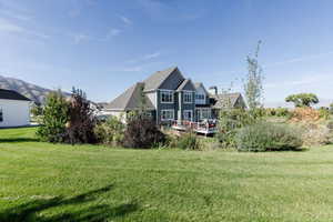 Back of property featuring a lawn and a chimney
