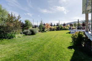 View of grassy yard with a deck