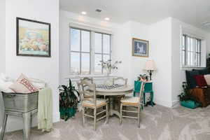 Dining space with light carpet, plenty of natural light, and recessed lighting