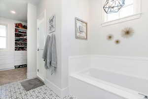 Bathroom with a garden tub, a spacious closet, a shower stall, and light carpet