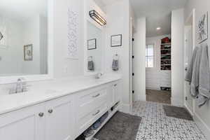 Bathroom with a walk in closet, double vanity, a stall shower, and light tile patterned flooring