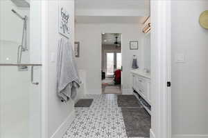 Ensuite bathroom featuring vanity, a shower stall, and a ceiling fan