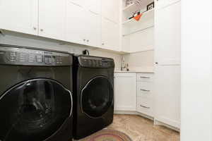 Laundry area with independent washer and dryer and cabinet space