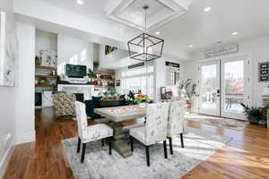 Dining room with french doors, dark wood-style floors, a fireplace, plenty of natural light, and recessed lighting