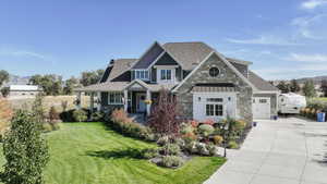 Craftsman-style house with a front lawn, a mountain view, a standing seam roof, driveway, and a metal roof