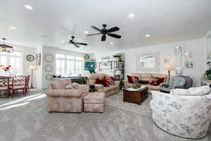 Living room with carpet flooring, a ceiling fan, and recessed lighting