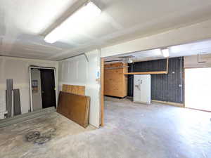 Basement featuring white refrigerator with ice dispenser