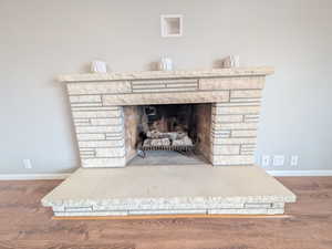 Detailed view of wood finished floors and a fireplace