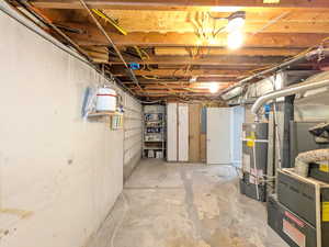 Unfinished below grade area with heating unit and water heater
