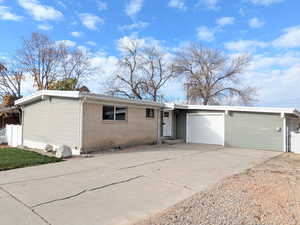 Single story home with brick siding, concrete driveway, and a garage