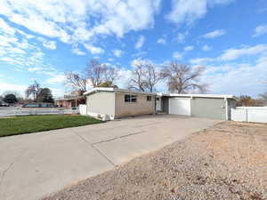 View of front of house with concrete driveway, brick siding, and an attached garage