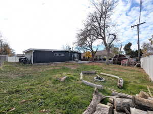 Fenced backyard featuring an outbuilding and a fire pit