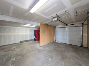 Garage featuring a garage door opener and electric panel