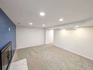 Finished below grade area with carpet flooring and recessed lighting
