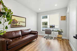 Office space with light wood-type flooring and recessed lighting
