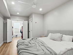 Bedroom featuring a spacious closet, light wood-style flooring, recessed lighting, and ceiling fan
