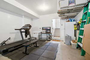 Workout room featuring a textured ceiling and concrete flooring
