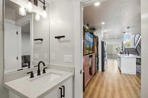 Bathroom featuring vanity, a textured ceiling, light wood-style floors, and recessed lighting