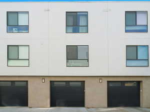 View of front facade with a garage and stucco siding