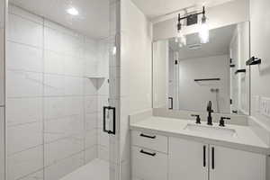 Full bathroom with vanity and a stall shower