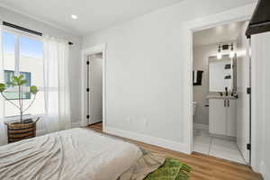 Bedroom featuring light wood-type flooring and ensuite bathroom