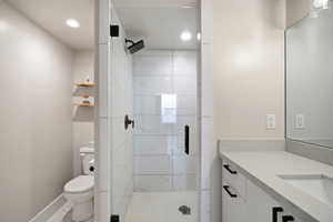 Full bath with a shower stall, vanity, and recessed lighting