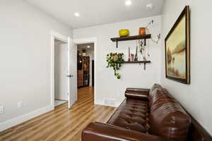 Living room with light wood-style floors and recessed lighting