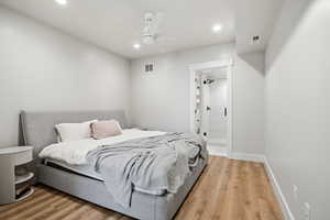 Bedroom with light wood finished floors, ceiling fan, connected bathroom, and recessed lighting