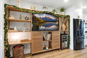 Detailed view of appliances with stainless steel finishes, beverage cooler, and wood finished floors