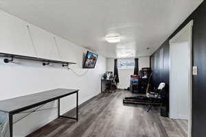 Office area with a textured ceiling and wood finished floors