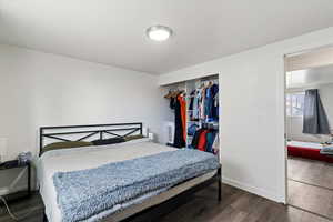 Bedroom featuring dark wood-style floors and a closet
