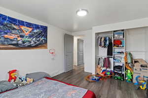 Bedroom featuring wood finished floors and a closet