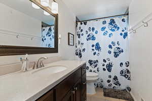Full bath featuring vanity, a shower with curtain, and light tile patterned floors