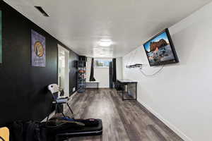 Interior space with a textured ceiling and dark wood-style floors