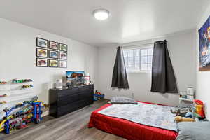 Bedroom with wood finished floors and baseboards