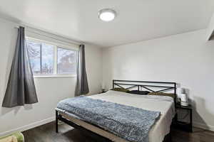 Bedroom featuring dark wood-type flooring and baseboards