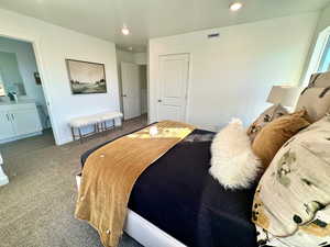 Bedroom with carpet flooring, connected bathroom, recessed lighting, and a textured ceiling