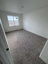 Carpeted empty room featuring baseboards