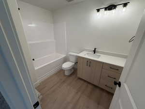 Bathroom with vanity, light wood-style flooring, and tub / shower combination