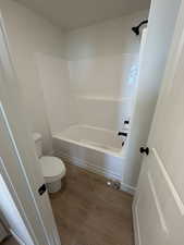 Full bathroom featuring dark wood-style floors and bathing tub / shower combination