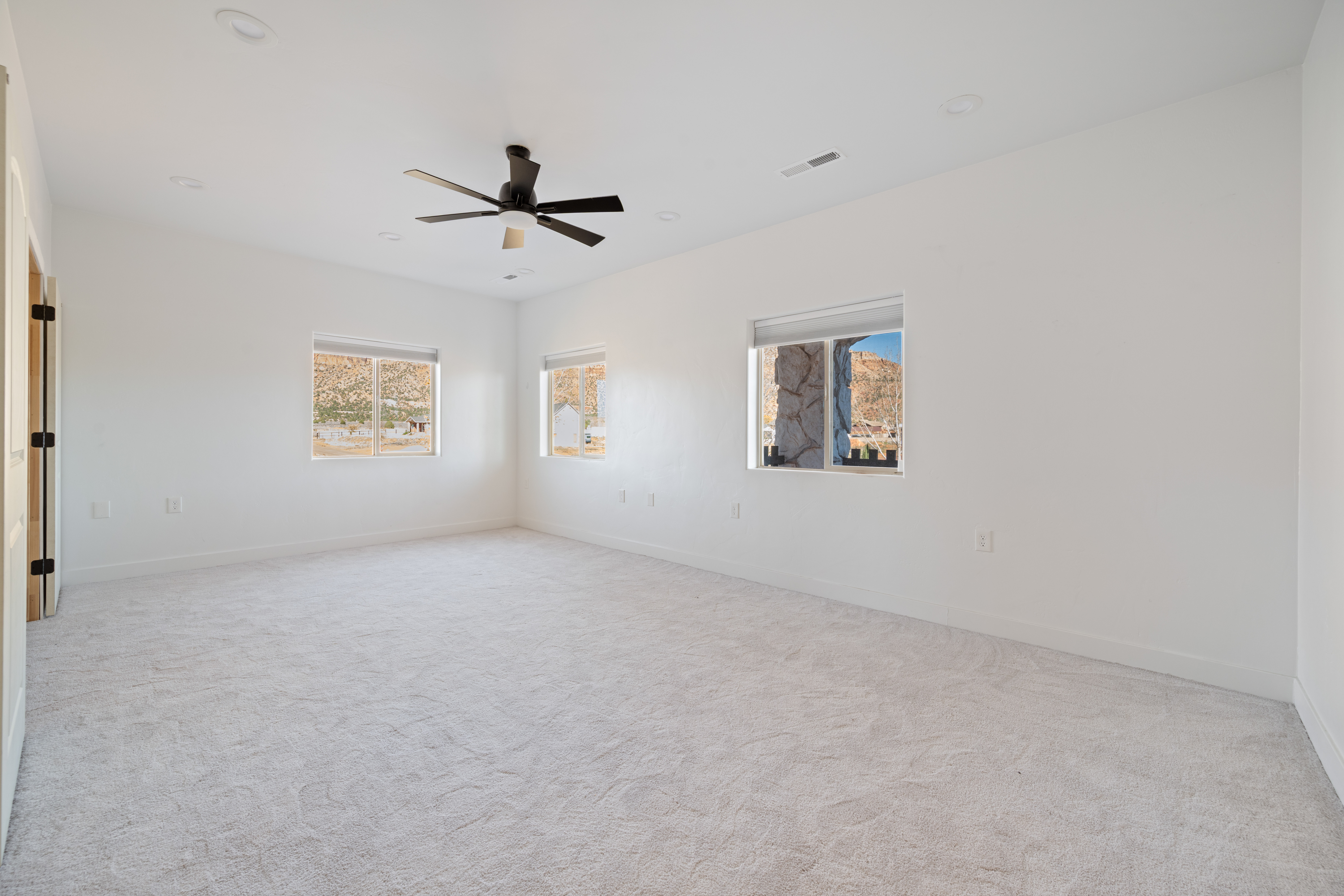 Unfurnished room featuring light carpet, a ceiling fan, and recessed lighting