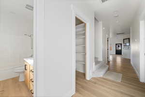 Corridor featuring light wood-type flooring and baseboards