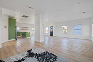 Unfurnished living room with plenty of natural light, recessed lighting, and light wood-type flooring